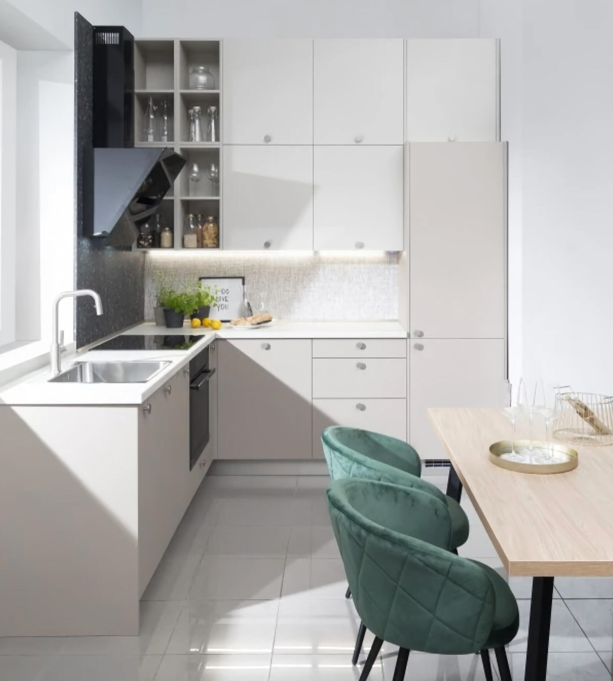 Moderná kuchyňa v bielom prevedení s elegatnými zelenými stoličkami a mramorovými akcentmi.
