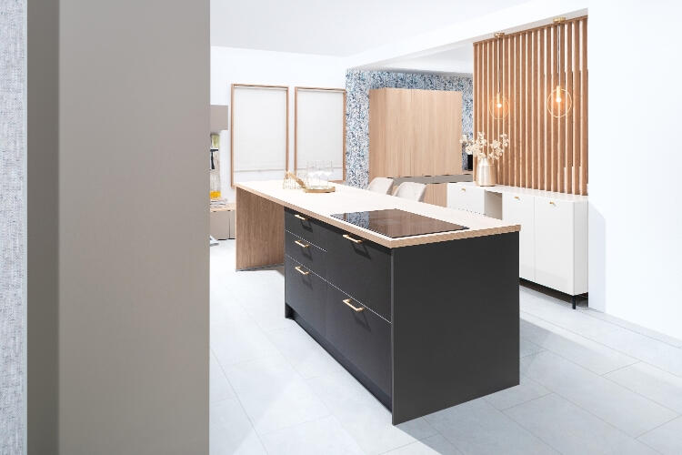 Decodom na mieru vytvorená kuchyňa s čiernym ostrovným pultom, drevenými prvkami a elegantným osvetlením.