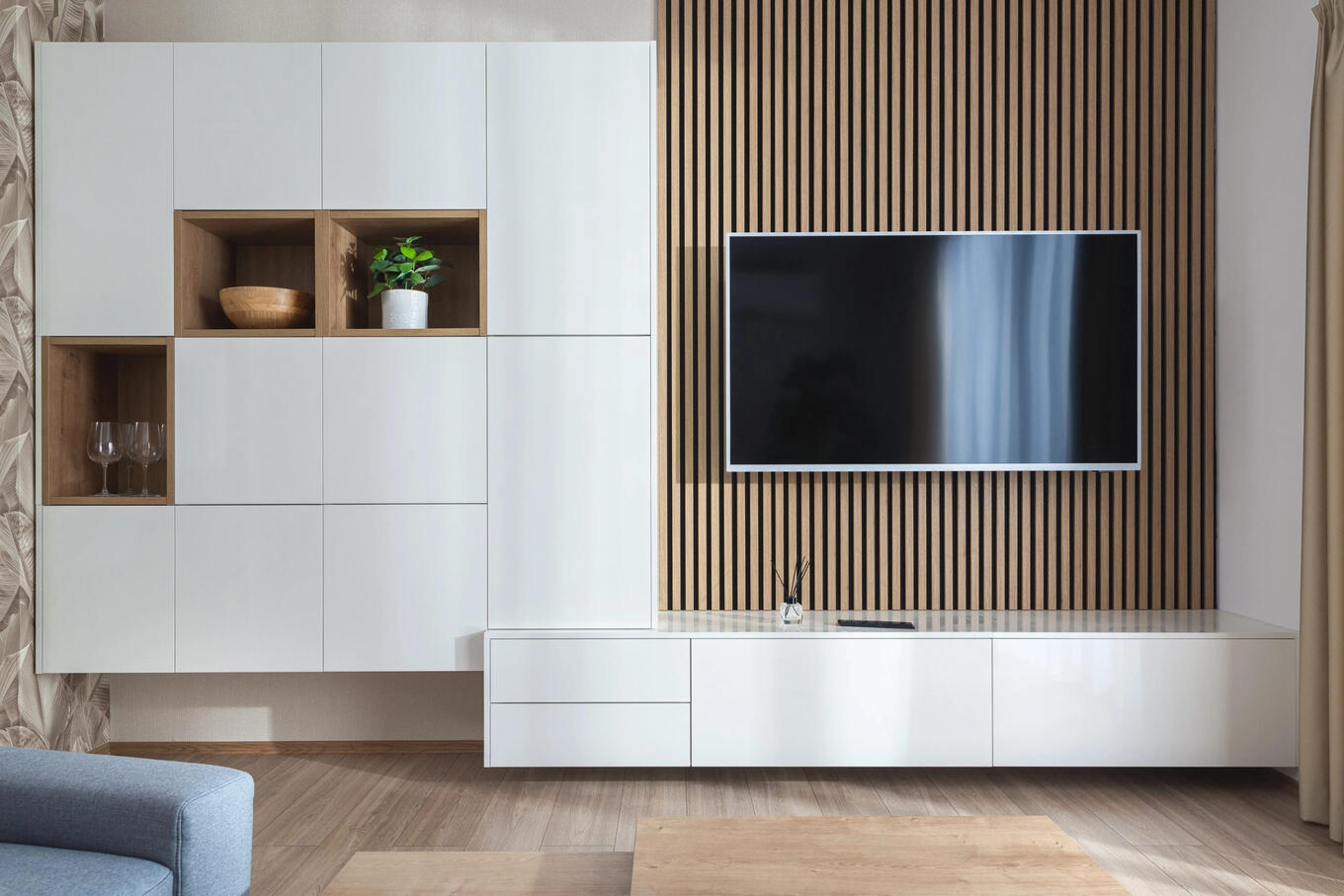 Čisté línie a svetlé tóny v tejto Decodom obýačke poskytujú ideálny mix funkčnosti a štýlového dizajnu pre srdce domova. Moderná Decodom obývačka na mieru s bielymi skrinkami a drevenými akcentmi pre svetlý a vzdušný pocit.