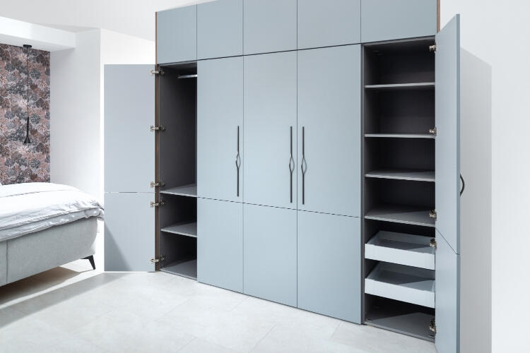 Decodom prispôsobiteľná šatníková skriňa v minimalistickom šede s dômyselnými úložnými riešeniami pre moderné spálne. Štýlová šedá šatníková skriňa na mieru od Decodom s otvorenými policami a zásuvkami.